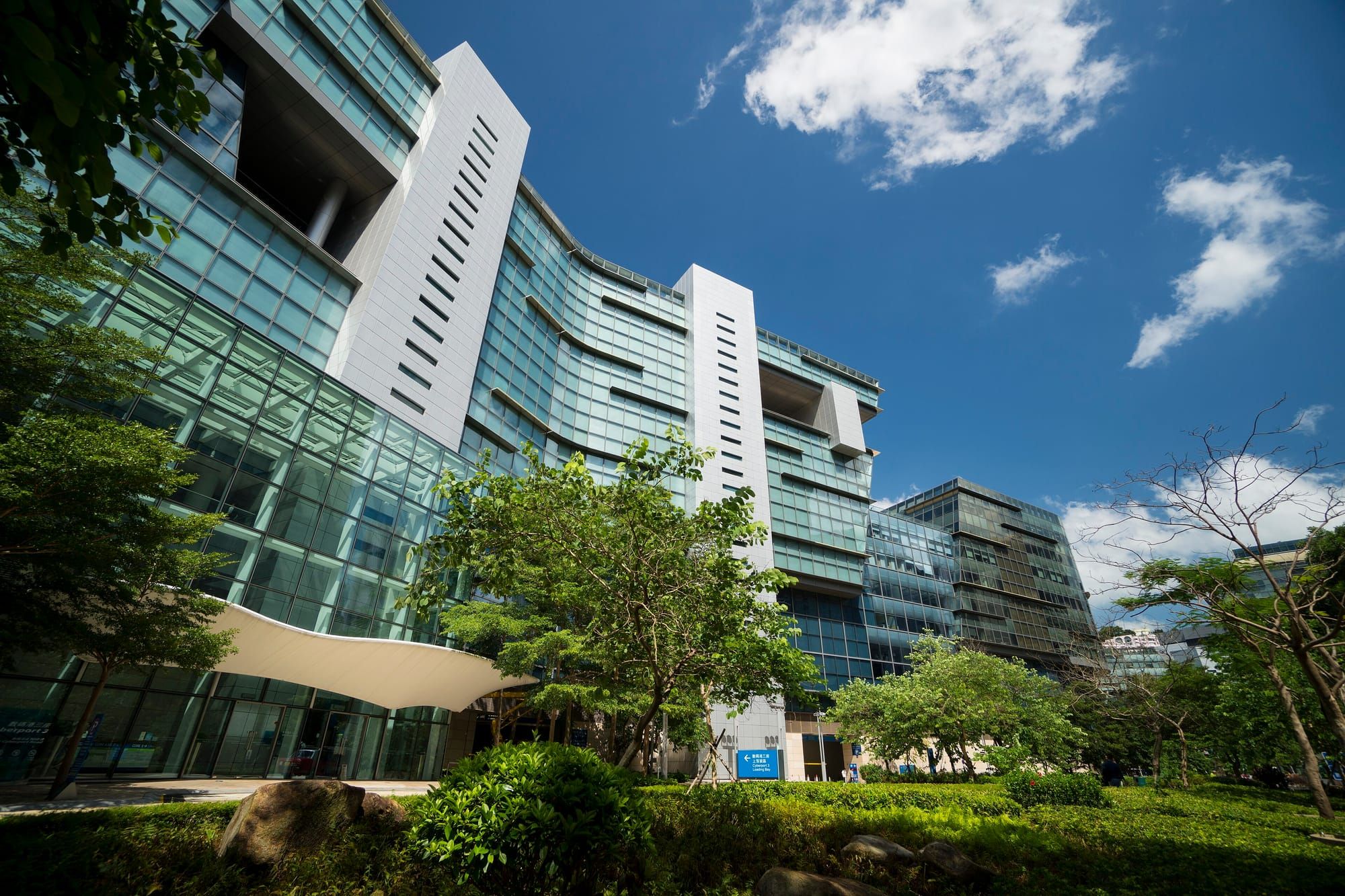 Cyberport office building surrounded by trees under a blue sky